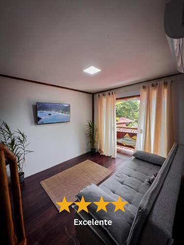 a living room with a couch with five stars on the floor at Flats do Pe na Areia in Abraão