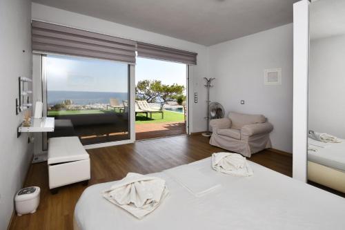 a bedroom with a bed and a view of the ocean at Ocean Island Villa in Achlia
