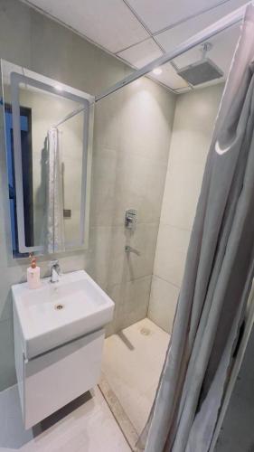 La salle de bains est pourvue d'un lavabo et d'une douche. dans l'établissement Interstellar View at 22nd Floor, à New Delhi