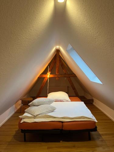 a bed in the attic with a roof at Hexenhaus in Keidelheim