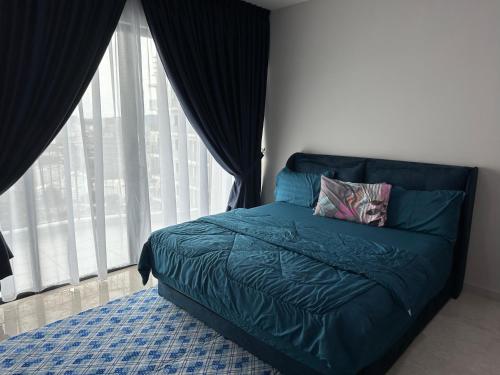 een slaapkamer met een blauw bed en een groot raam bij Datum Jelatek Sky Resident KLCC by Deen in Kuala Lumpur