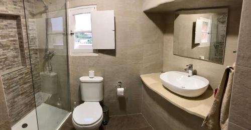 a bathroom with a toilet and a sink and a shower at Villa Julia in Xewkija