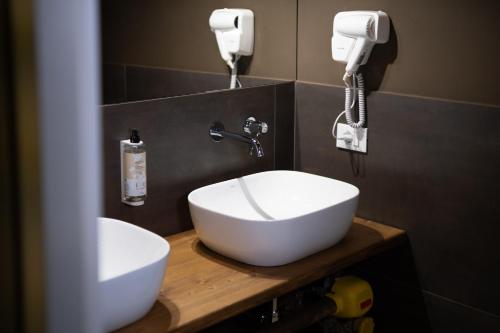 a bathroom with a white sink and a hair dryer at Hostelò - Luxury Hostel in Palermo