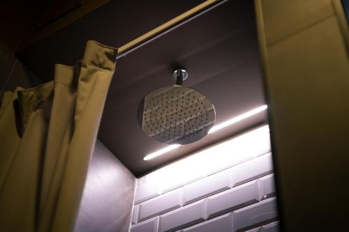 a pendant light in a bathroom with a curtain at Hostelò - Luxury Hostel in Palermo