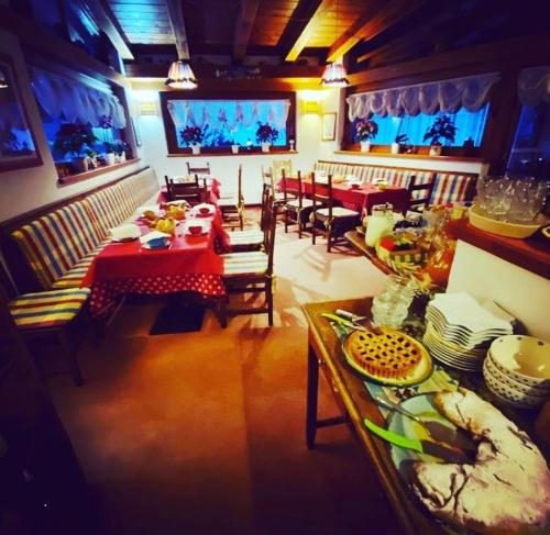 a dining room with tables and chairs and a television at HOTEL LA NIGRITELLA in Bardonecchia