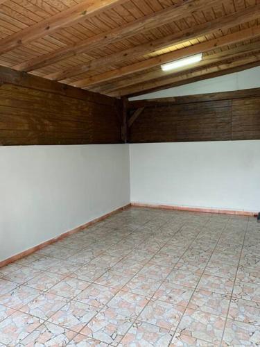 Cette chambre vide est dotée de murs blancs et d'un plafond en bois. dans l'établissement Logement avec parking à proximité de l’aéroport, à Les Abymes