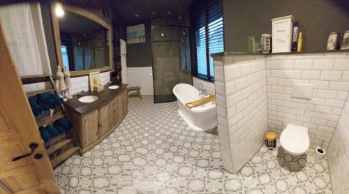 a large bathroom with a tub and a sink and a toilet at Dream@coast in Nieuwpoort