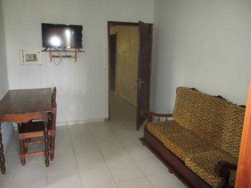 a living room with a couch and a table and a television at Residence Kathyly in Diego Suarez