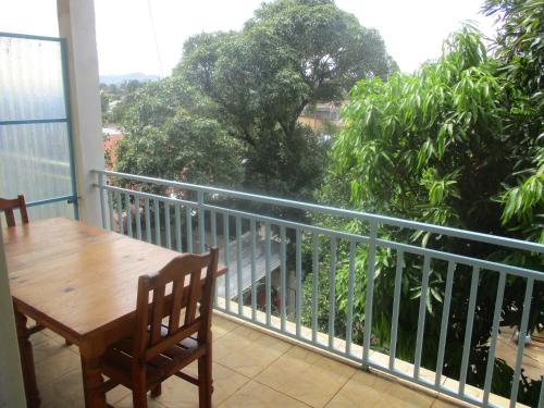 a balcony with a table and a view of trees at Residence Kathyly in Diego Suarez