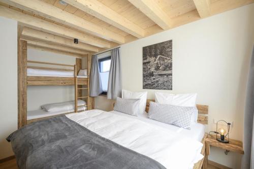 翁特拉梅爾高的住宿－Wetzstoa Chalet in Unterammergau mit Sauna und Whirlpool，卧室配有一张白色的大床和双层床。