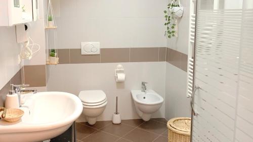 a bathroom with a toilet and a bidet and a sink at SulLago Appartamenti - Appartamento incantevole con Piscina in Castiglione del Lago