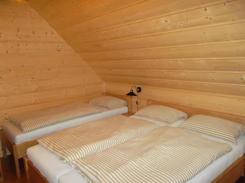 2 łóżka w pokoju z drewnianymi ścianami w obiekcie Chata Sipkova II w Tierchowej