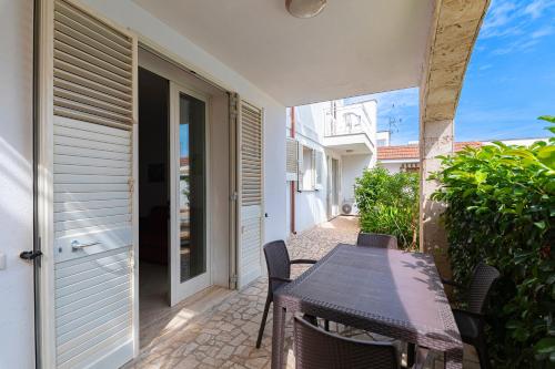 a patio with a table and chairs on a balcony at Le Piscine RELAX in Nardò