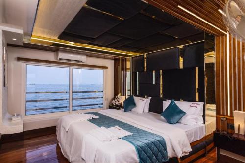 a bedroom with a large bed with a large window at Double Decker Houseboat in Alleppey
