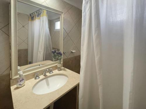 uma casa de banho com um lavatório e uma cortina de chuveiro em Complejo Hermoseños - by Me Nomad em Monte Hermoso