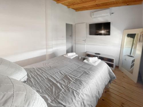 um quarto branco com uma cama e uma televisão em Complejo Hermoseños - by Me Nomad em Monte Hermoso