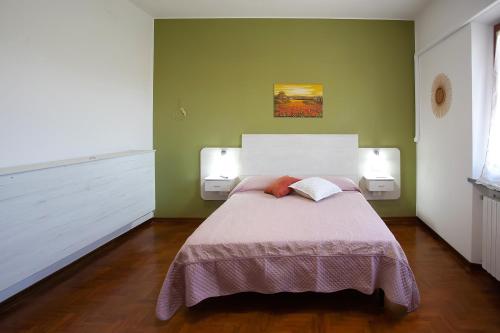 a bedroom with a large bed with two lamps at B&B GREEN HOUSE in Cascina