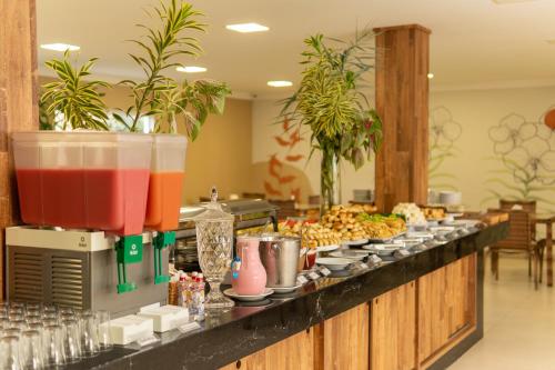 a buffet line with food and drinks on it at Orquídeas Praia Hotel in Porto Seguro