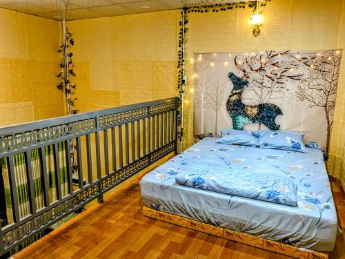 a bed on a balcony with a mural of a deer at Coco Happy Farm in Ben Tre