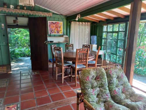 ein Esszimmer mit einem Tisch und Stühlen in der Unterkunft casa do morro linda vista para ate 08 pessoas in Imbituba