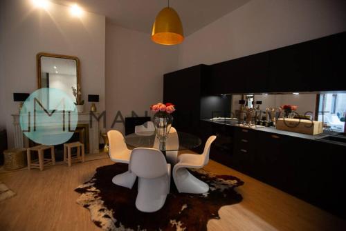 a living room with a table and chairs and a kitchen at Extérieur Chartrons Jardin Public Quais Quinconces XAVIER ARNOZAN in Bordeaux