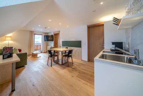 a kitchen and living room with a sink and a table at Hotel Hochsölden in Sölden