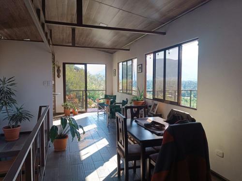 a dining room with a table and chairs and windows at Apartment Ujarraz Irola's in Cartago