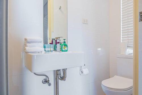 a white bathroom with a sink and a toilet at Charming house in Leichhardt in Sydney