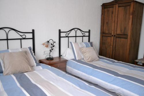 two beds sitting next to each other in a bedroom at Apartamentos La Sierra in Villalba de la Sierra