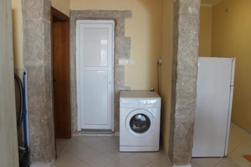 a white washing machine in a room with a door at Апартаменты Jasmine in Bar