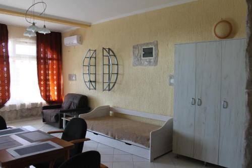 a living room with a bed and a table and chairs at Апартаменты Jasmine in Bar