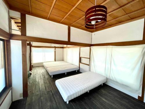 una camera con due letti e un soffitto di ギャラリー宿　INNAHOUSE ANDAGALLERY a Murotsu