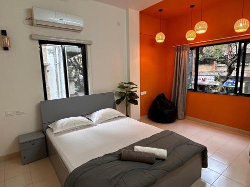 Un dormitorio con una cama grande con paredes naranjas. en Autumn: 1Bhk with Bathtub at Koregaon Park, en Pune