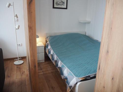 Ce lit se trouve dans une petite chambre dotée d'un matelas vert. dans l'établissement Apartman Duda, à Kopaonik