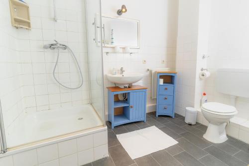 een badkamer met een wastafel, een toilet en een bad bij Strandkoje in Flensburg