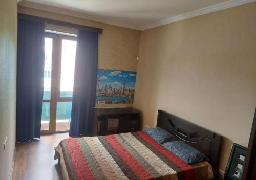 um quarto com uma cama e uma grande janela em GOAL ApartmentS 2 em Tbilisi