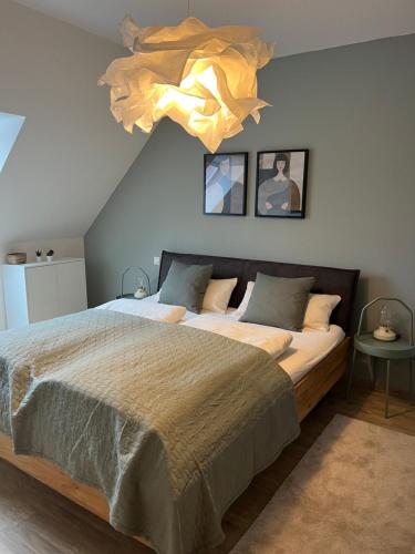 sypialnia z dużym łóżkiem i żyrandolem w obiekcie FreiTraum Apartments No 2 im Zentrum von Bad Neustadt w mieście Bad Neustadt an der Saale