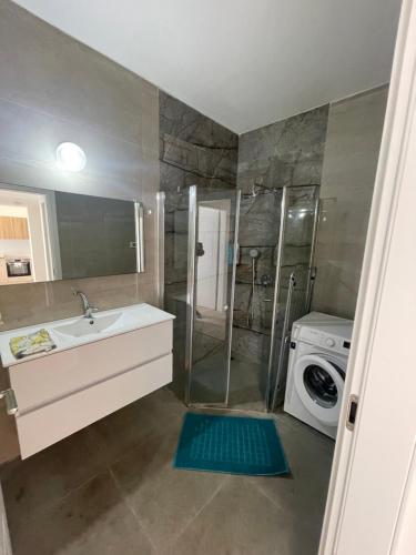 a bathroom with a sink and a washing machine at Beautiful 2BR near Mahane Yehuda in Jerusalem