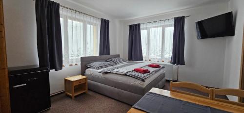 niewielka sypialnia z łóżkiem i telewizorem w obiekcie Apartment Ulrich w mieście Jablonec nad Jizerou