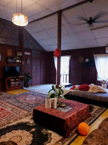 a large room with two beds and a table at Rumah Kayu Aboh in Kuala Terengganu