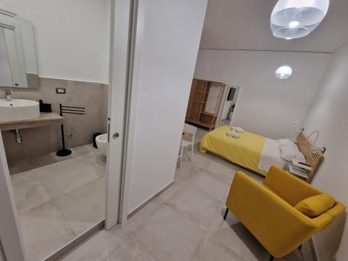 - une chambre avec un lit et une salle de bains pourvue d'un lavabo dans l'établissement Neapolitan Skyscraper Suites, à Naples