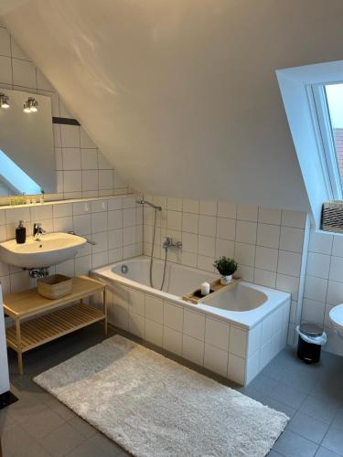 a bathroom with a bath tub and a sink at FreiTraum Apartments No 2 im Zentrum von Bad Neustadt in Bad Neustadt an der Saale