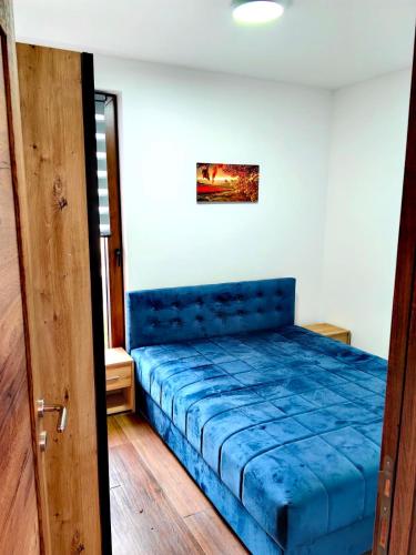 a bedroom with a blue bed in a room at Borovi 3, apartman 3 in Divčibare