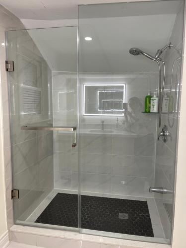 a shower with a glass door in a bathroom at Luxury Suite with King Bed-4 minutes to The Falls in Niagara Falls