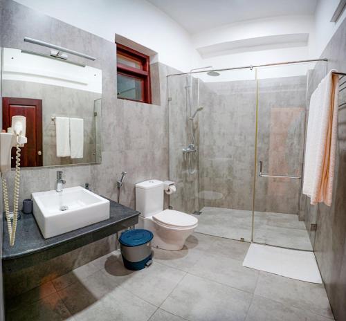 a bathroom with a sink toilet and a shower at Weleges Place in Hikkaduwa