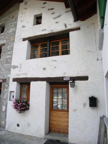 a white building with a wooden door and a window at Chalet Martina in Macugnaga