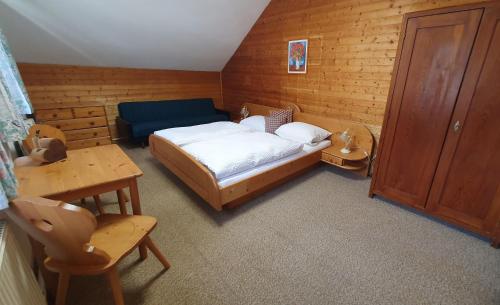 Un pequeño dormitorio con una cama y una mesa. en Neufangbauer, Familie Sabine und Peter Hauser, en Dorfgastein