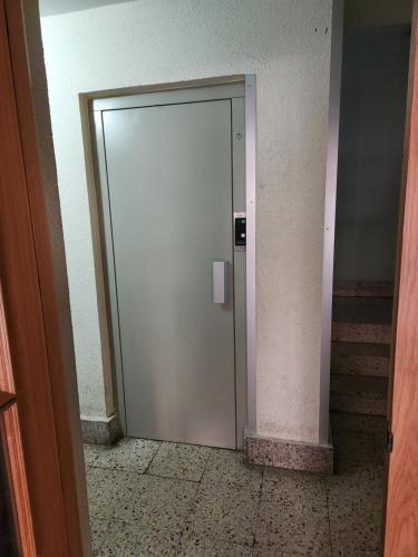 una puerta blanca en un pasillo con escaleras en Moderno Apartamento Cerca del centro en León en León