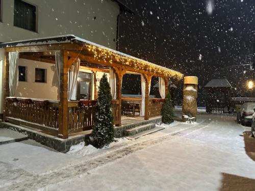 a gazebo with christmas lights in the snow at Casa Maramureșană in Vişeu de Sus
