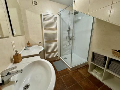 ein weißes Bad mit einem Waschbecken und einer Dusche in der Unterkunft Charmantes Ferienhaus an der Mosel in Ediger-Eller
